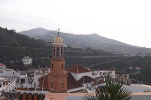 a building with a clock tower on top of it at Casa Elvira in Cómpeta