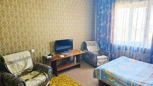 Zimmer mit einem Schreibtisch, einem Computer und einem Bett in der Unterkunft Apartment na VEFe in Bischkek