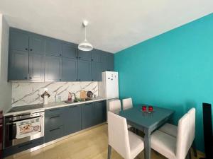 a kitchen with blue cabinets and a table with chairs at S&E Apartment in Pogradec
