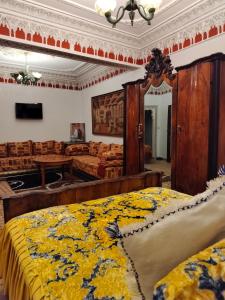 PALAIS LARAICHI Riad la porte bleue suites في فاس: غرفة نوم بسريرين مع بطانيه صفراء وزرقاء