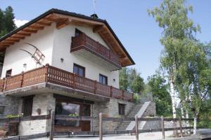 a house with a balcony on top of it at Chambres D'Hotes Les Fleurs in Pila