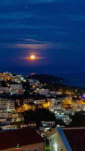 a view of a city at night with the moon at Apartments Tati in Ulcinj
