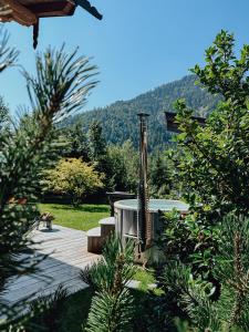 d'un bain à remous au milieu d'une cour arborée. dans l'établissement Chalet Nordic mit privatem Whirlpool und Sauna, à Bayrischzell