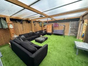 a living room with black furniture and green grass at Exquisite Luxury Studio in Mitcham