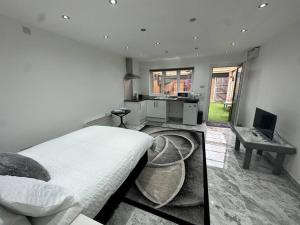 a bedroom with a bed and a kitchen with a desk at Exquisite Luxury Studio in Mitcham