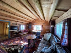 un soggiorno con divano e tavolo di Elveseter - log cabin with an amazing view a Lunde