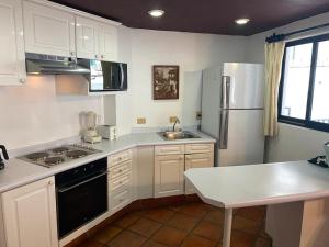 une cuisine avec des armoires blanches et un réfrigérateur dans l'établissement one Beach st hotel - beach Front 2BD 2BA WITH BALCONY in Zona Romantic Puerto Vallarta, à Puerto Vallarta