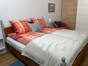 1 cama con manta y silla en una habitación en Przy Łazienkach Królewskich, en Varsovia