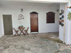 a room with a door and two chairs and a table at Confortáveis e práticas Kitnets em Belo Horizonte in Venda Nova