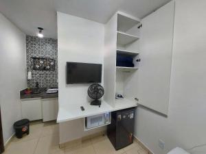 uma sala de estar com uma televisão de ecrã plano na parede em Confortáveis e práticas Kitnets em Belo Horizonte em Venda Nova