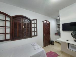 a room with a bed and a tv on a wall at Confortáveis e práticas Kitnets em Belo Horizonte in Venda Nova