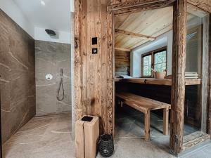a wooden bathroom with a bench and a shower at Chalet Nordic mit privatem Whirlpool und Sauna in Bayrischzell