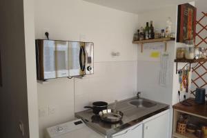 uma pequena cozinha com um lavatório e um micro-ondas em Harmonia, Studio (30m2) en centre ville em Bordeaux