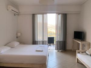 een hotelkamer met een bed en een televisie bij Foto Studios in Himare
