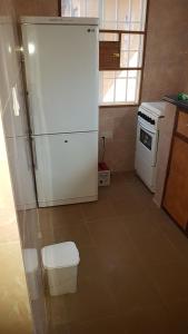 a kitchen with a white refrigerator and a stove at Annex House For Rent in Manjai Kunda