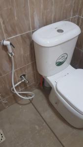 a white toilet in a bathroom with a hose at Annex House For Rent in Manjai Kunda