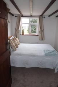 a bedroom with a white bed and a window at Garn Lodge in Newtown
