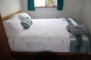 a bed with white sheets and pillows in a bedroom at Garn Lodge in Newtown