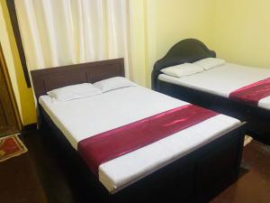 two twin beds in a room with at Doranagala Holiday Home in Matale