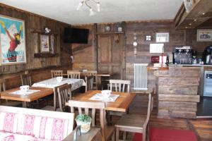 a restaurant with wooden tables and chairs and a kitchen at Chambres D'Hotes Les Fleurs in Pila