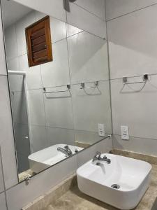 y baño con lavabo blanco y espejo. en Espaço conforto e tranquilidade CASAVEG en Canoa Quebrada