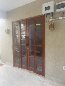 a pair of wooden doors on the side of a building at Espaço conforto e tranquilidade CASAVEG in Canoa Quebrada