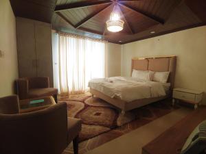 - une chambre avec un lit, une chaise et une fenêtre dans l'établissement Himalaya Villa's, à Murree