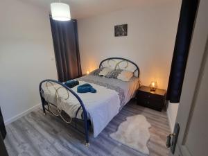 Schlafzimmer mit einem Bett mit schwarzem Rahmen in der Unterkunft Appartement Rethel - Netflix - Marc & cécile in Rethel