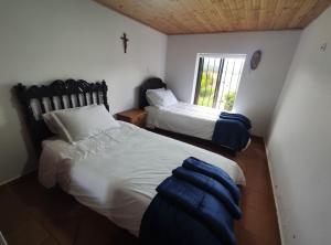 1 dormitorio con 2 camas y ventana en Cabañas & Glamping ILLARI Boutique, en Paipa
