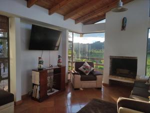 TV a/nebo společenská místnost v ubytování Cabañas & Glamping De Ruana Por Boyacá