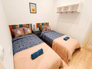 duas camas num pequeno quarto com duas em By Liceu Rooms em Barcelona