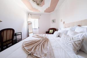 a bedroom with a large white bed with white sheets and pillows at A Casa da Marina - Sitio in Nazaré