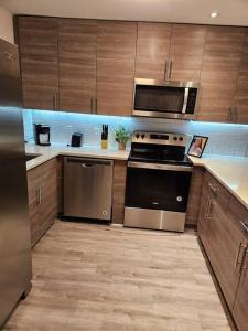 a kitchen with stainless steel appliances and wooden cabinets at Midtown Atl Gem located 10 minutes from everything! in Atlanta