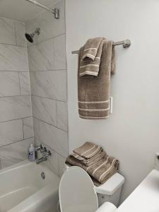 a bathroom with a toilet and a shower and towels at Midtown Atl Gem located 10 minutes from everything! in Atlanta