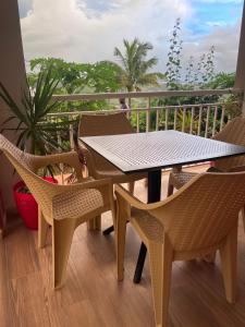 a table and chairs on top of a balcony at Résidence Terre et Passion in Ducos