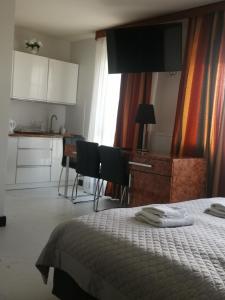 een slaapkamer met een bed en een tafel en een keuken bij Apartament prywatny z aneksem kuchennym w hotelu Royal Tulip Sand in Kołobrzeg