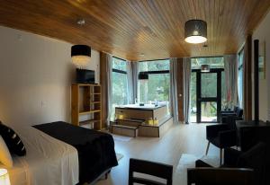um quarto com uma cama e uma sala de estar com uma banheira em Pousada Encanto do Avencal em Urubici