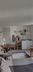 a living room with a table and a kitchen at Fuglsanggaard. Private annex in nature. in Præstø