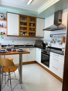 a kitchen with white cabinets and a wooden table at Apartamento playa Vigo in Vigo