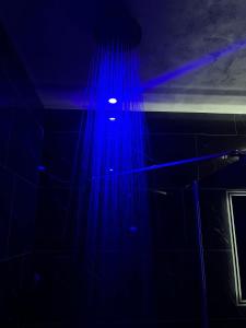 a blue light in a dark room with a window at Chambre romantique avec Spa B in Gruny