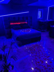 een slaapkamer met een bed in een blauwe kamer bij Chambre romantique avec Spa B in Gruny