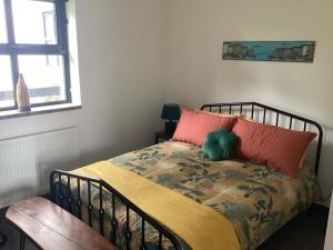 a bedroom with a bed with a red pillow at River Cottage in Portglenone