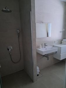 ein Bad mit einem Waschbecken und einer Dusche in der Unterkunft Apartments Krkoč in Izola