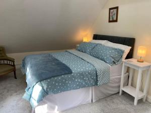 a bedroom with a bed and a table with a lamp at The Nook at Tatchbury House, New Forest in Ower