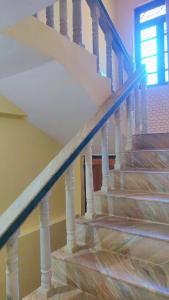 a staircase with a blue hand rail in a house at The Sea Breeze in Nuvem