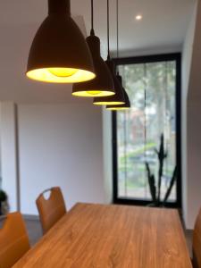 a dining room table with lights hanging over it at Logie De Terp in Knokke-Heist