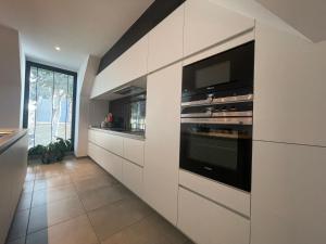 uma cozinha com armários brancos e um grande forno em Logie De Terp em Knokke-Heist