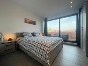 een slaapkamer met een bed en een groot raam bij Logie De Terp in Knokke-Heist