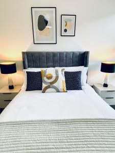 a bedroom with a large white bed with two lamps at Luxury Double Bedroom, near Heathrow Airport in Hillingdon