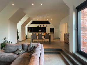 a living room with a couch and a dining room at Logie De Terp in Knokke-Heist